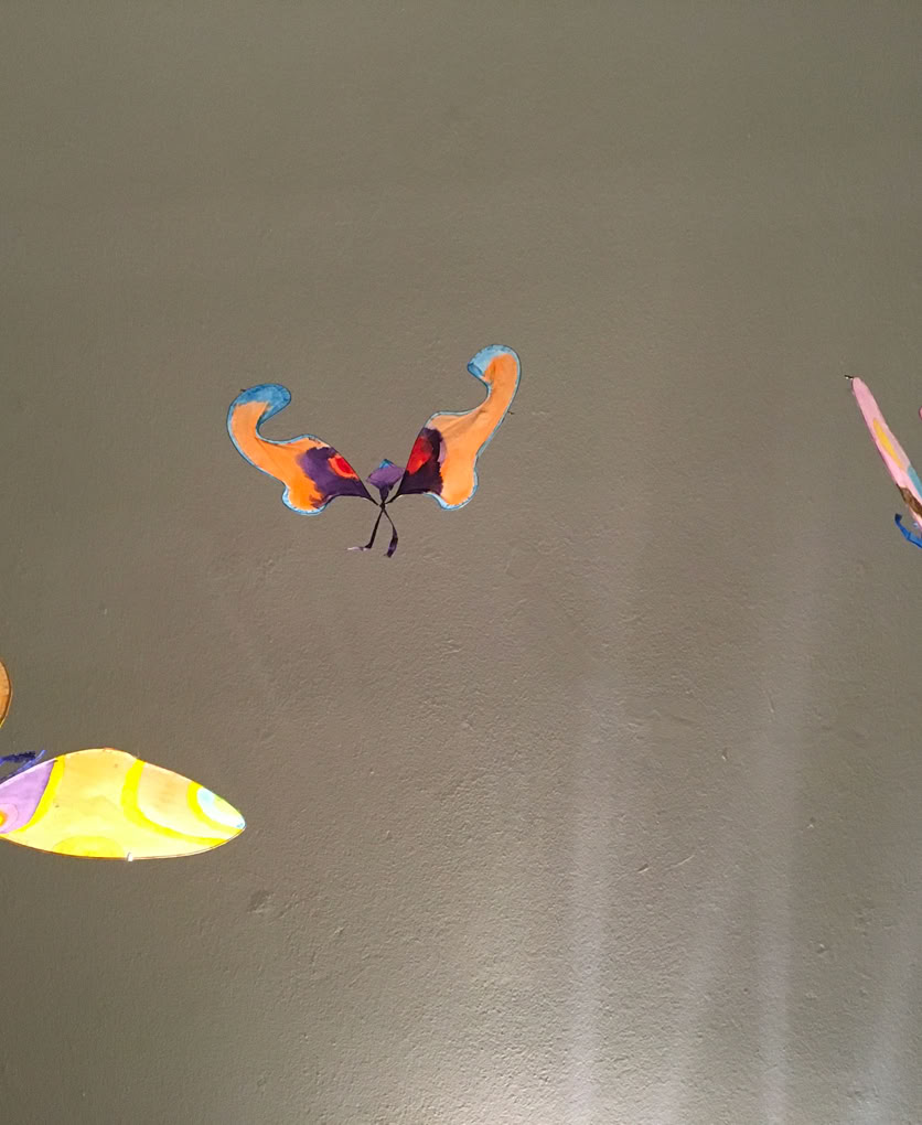 Installation suspendue et poétique de papillons en papier de soie. Dimension 3 m.