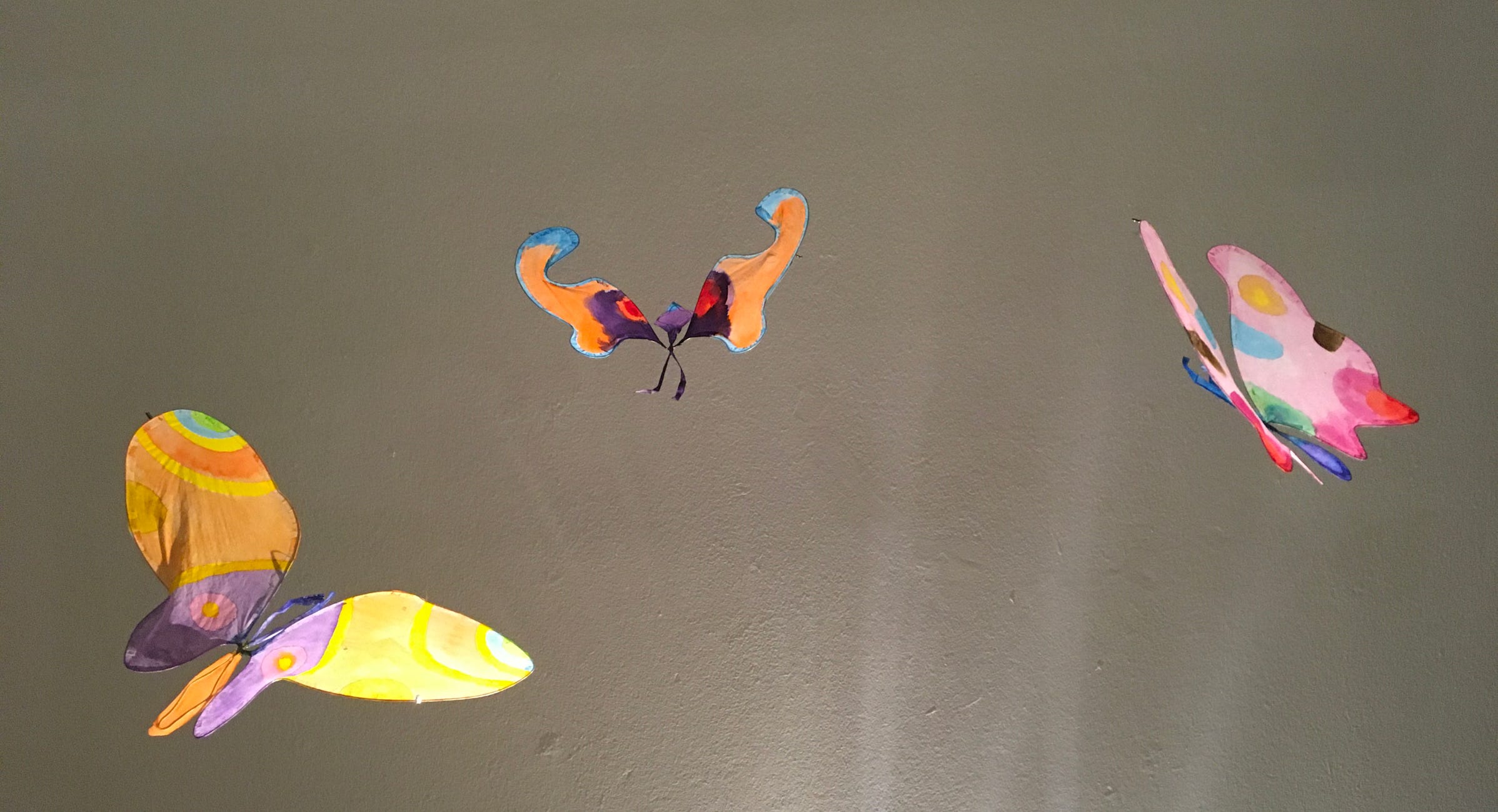 Installation suspendue et poétique de papillons en papier de soie. Dimension 3 m.