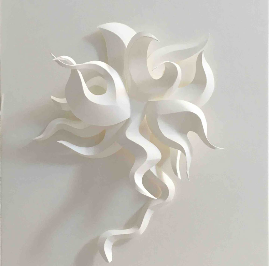 Sculpture en papier blanc avec des formes ondulées et entrelacées sur un fond blanc.