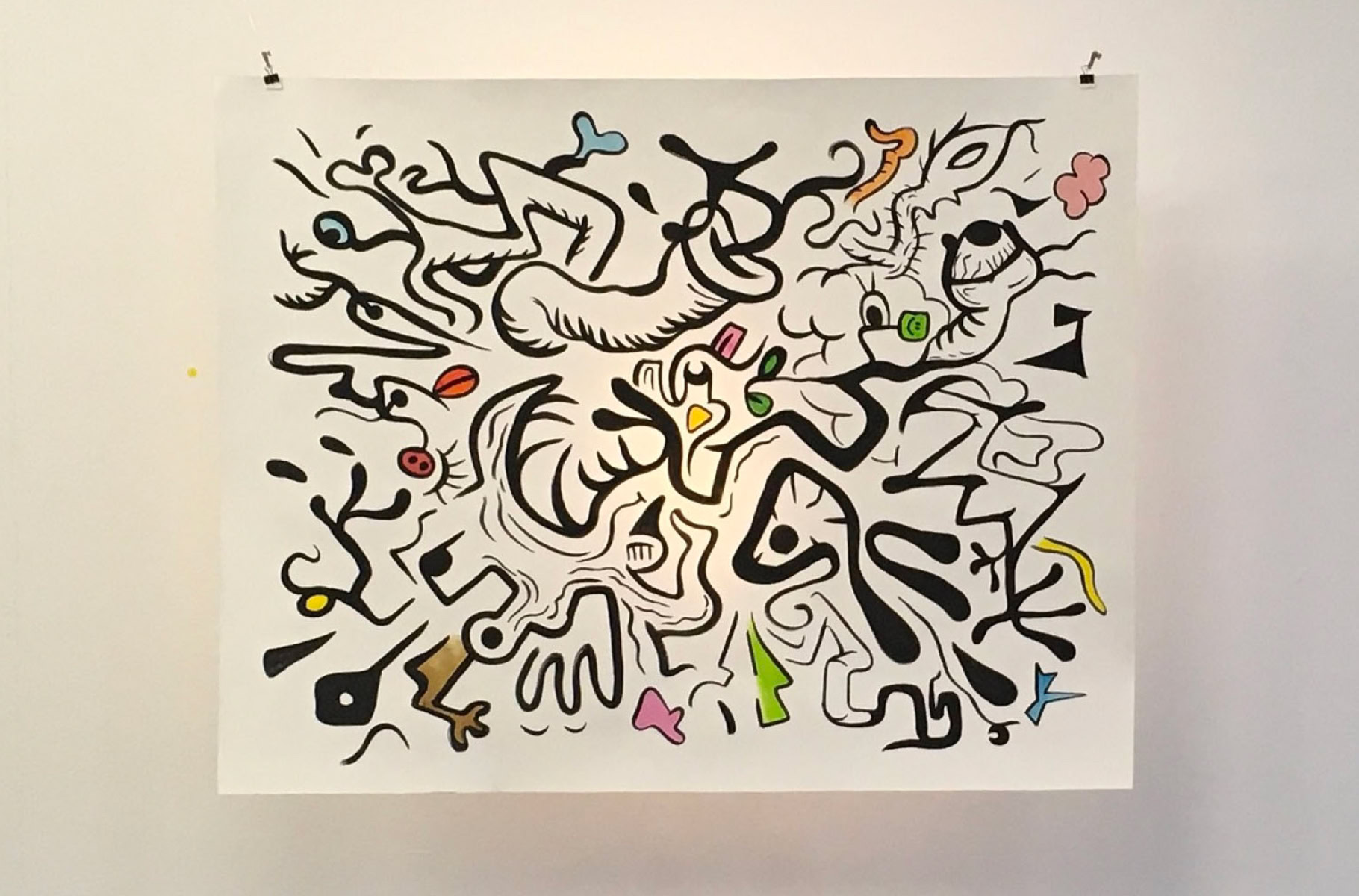 ne grande œuvre abstraite colorée accrochée sur un mur blanc.