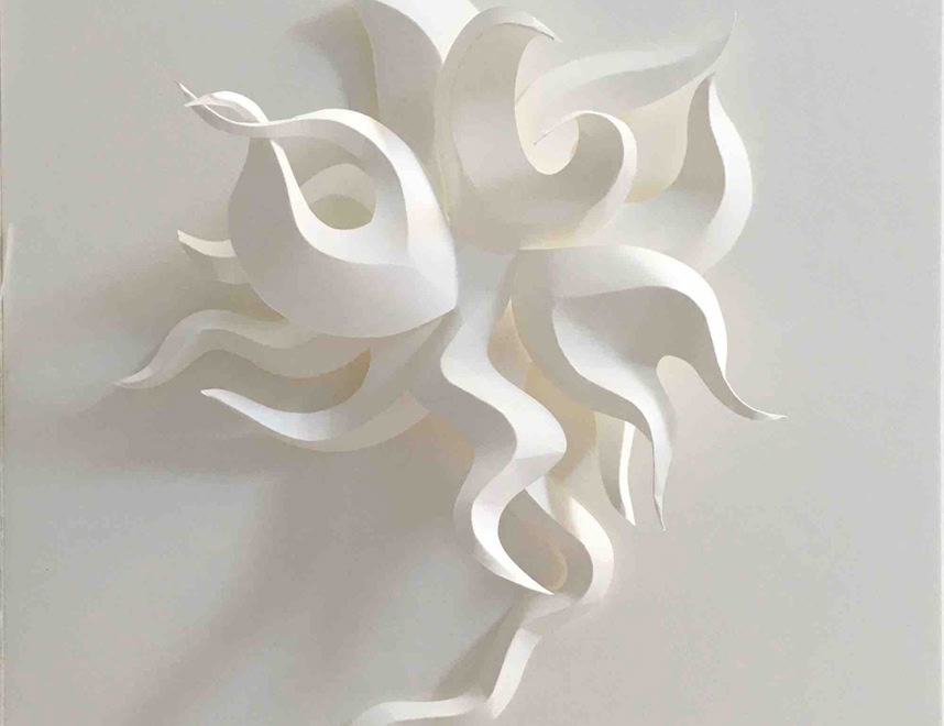 Sculpture en papier blanc avec des formes ondulées et entrelacées sur un fond blanc.